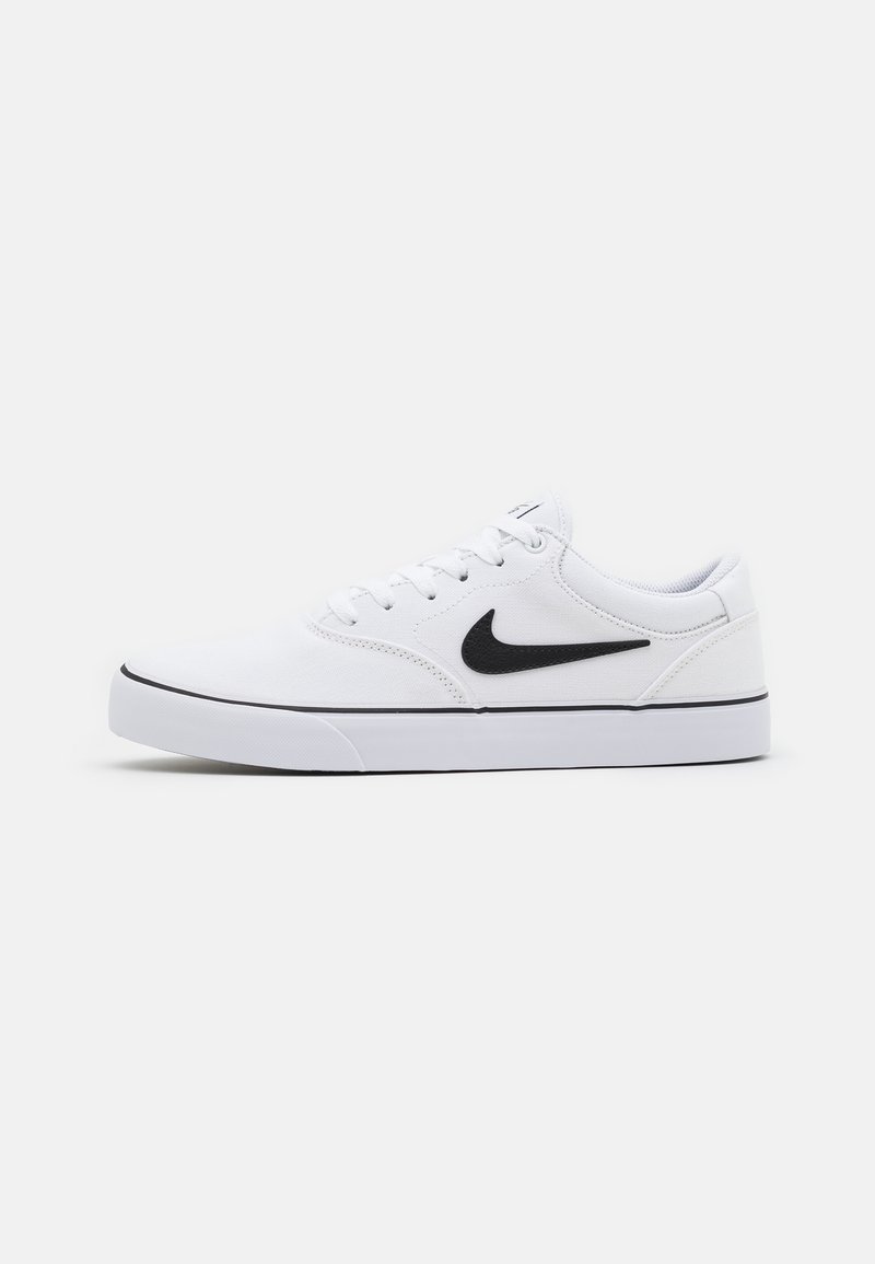 White canvas sneakers with black accents, featuring a low profile, round toe, lace-up design, and a contrasting black stripe around the sole.