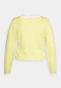 Sweater amarelo com padrão de coração, apresentando um design cropped, mangas longas e um colarinho branco. Textura suave com construção em malha.