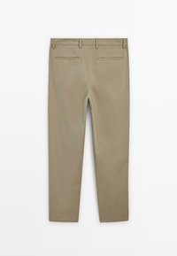 Beiga chinos med rak bendesign, med två bakfickor och slät textur. Midjan är sydd med tre synliga bältesöglor.