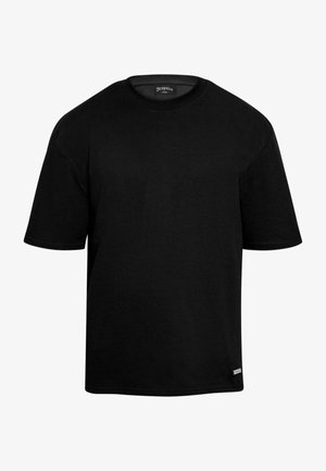 T-shirt noir à manches courtes en coton, avec un col rond et un design simple. Comprend une petite étiquette de marque en bas.