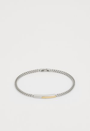 Bracelet en chaîne argentée avec une barre rectangulaire mettant en valeur un accent doré et un fermoir sécurisé sur fond blanc.