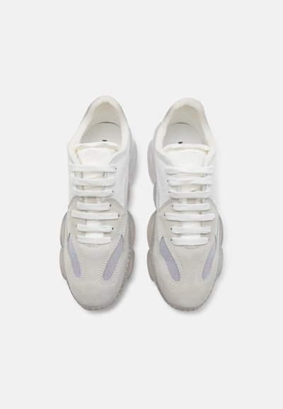 White and gray sneakers with suede and mesh material, rounded toe, thick translucent sole, and contrasting gray accents on the sides.