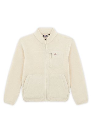 Jachetă din fleece de culoare crem, cu guler înalt, fermoar frontal, două buzunare laterale și un buzunar pe piept. Material moale, texturat.