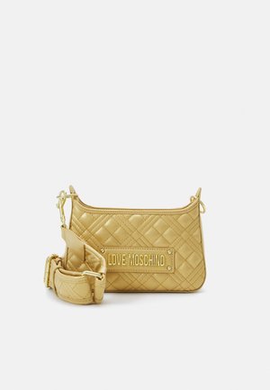 Bolso beige acolchado de Love Moschino con una correa gruesa ajustable y herrajes dorados sobre un fondo liso.