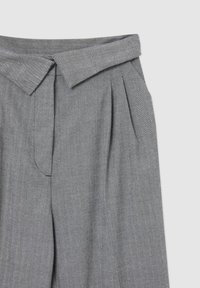 Pantaloni grigi a spina di pesce con vita piegata, pieghe, tasche laterali e vestibilità sartoriale, realizzati in tessuto leggero.