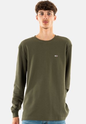 Chemise à manches longues vert olive en tissu texturé avec un col rond ; présente un petit logo sur la poitrine gauche.