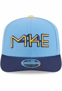 Helleblaue Kappe mit einem marineblauen Schirm. Beinhaltet besticktes "MKE" in Gelb und Marine. Enthält ein rundes Etikett mit der Aufschrift "9FIFTY Stretch-Snap."