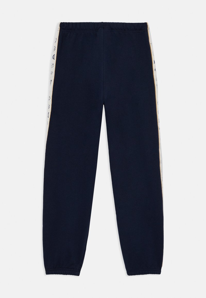 Pantaloni da tuta blu marine con vita elastica, caratterizzati da strisce laterali a contrasto con motivi grafici e polsini elastici alle caviglie.