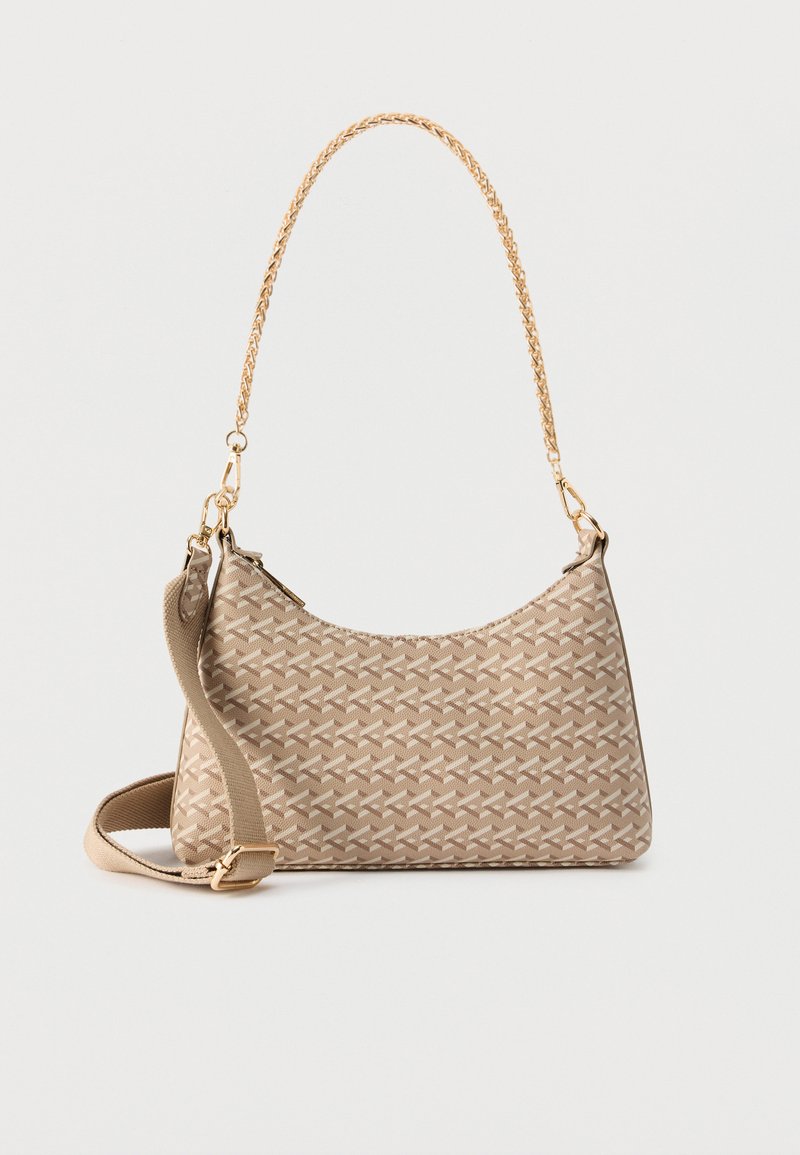 Sac à bandoulière beige avec motif géométrique, anse chaîne dorée et bandoulière en tissu beige détachable, présenté sur fond blanc.