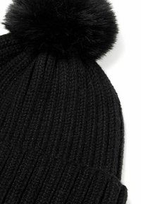 Musthave mustra must knit kootud beanie vertikaalse soonikuga, millel on peal suur must faux karusnaha pom-pom ja voltitud äär.