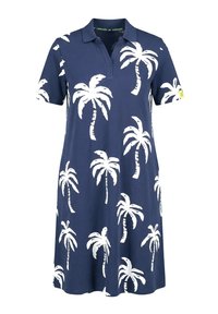Marineblå polo-kjole med korte ærmer, med hvide palmeprint og en lille gul mærkat på venstre ærme.