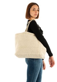 Beige, zachtgetextureerde boodschappentas met rechthoekige vorm, voorzien van dubbele gestreepte stoffen handvatten. Geschikt voor dagelijks gebruik.