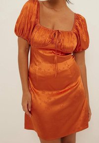 Vestido mini de satén naranja con mangas abullonadas, escote cuadrado y detalle de cordón. Presenta un patrón floral y una textura suave.