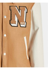 Giacca varsity color sabbia con un'insignia in pelle marrone a texture a forma di "N", maniche in pelle bianca, bottoni a pressione e tasche laterali.
