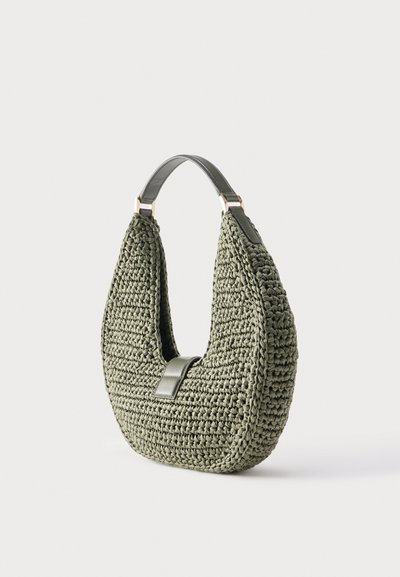 Green woven handbag with a single short handle and leather strap accent, displayed against a plain light background.