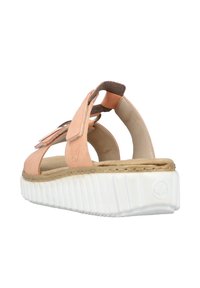 Sandale en daim pêche avec des brides ajustables, semelle en caoutchouc blanche et semelle intérieure texturée. Design incurvé avec un support au talon arrière.