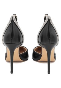 Scarpe nere con tacco alto, finitura lucida, punta affusolata e bordo nero con applicazioni di strass lungo il margine. Design con retro aperto.