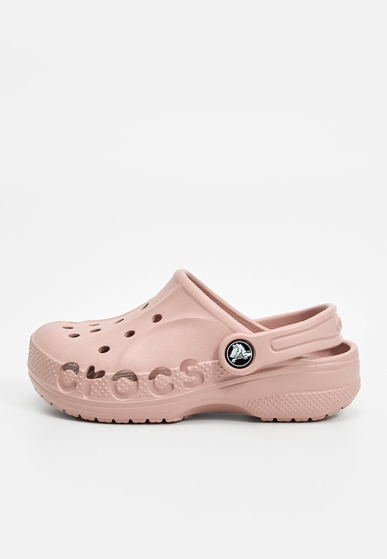 Jasnoróżowe klapki Crocs wykonane z gumy, z otworami wentylacyjnymi, tylnym paskiem i wytłoczonym logo "CROCS" po boku. Czarny ozdobny guzik.