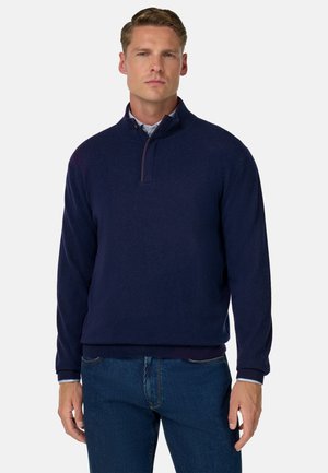 Dunkelblauer Pullover mit hohem Kragen, Viertelreißverschluss, gerippten Bündchen und Saum. Hergestellt aus weichem Stoff mit einem geraden Schnitt.