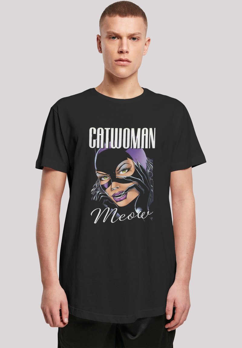 Svart bomull t-skjorte med et trykk av Catwoman med lilla detaljer, fet tekst som sier "CATWOMAN", og leken "Meow" tekst i hvitt.