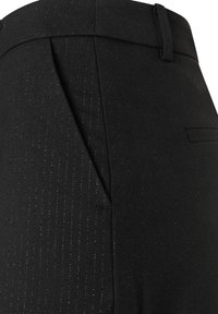 Black tailored trousers feature a textured fabric with subtle vertical stripes, a flat front, and a side pocket detail.