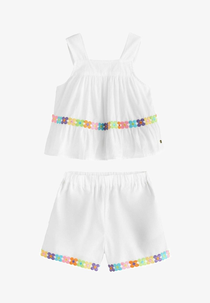 Witte mouwloze peutertop en short set met kleurrijke geborduurde bloemen langs de zoom van beide onderdelen.
