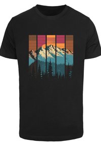 Zwart T-shirt met een grafisch ontwerp van een berglandschap in blauw, oranje, roze en bruin, met bomen en een kleurrijke lucht.