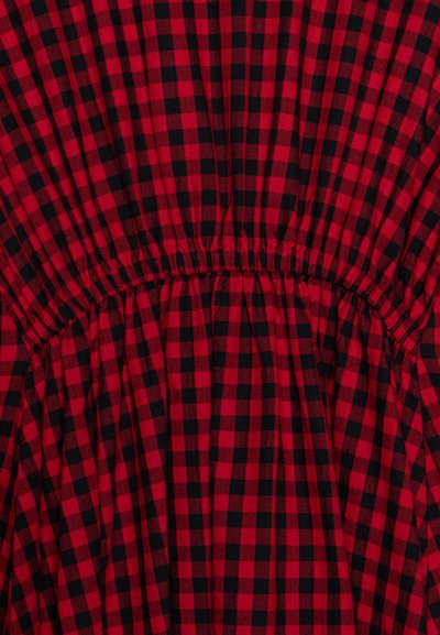 Κόκκινο και μαύρο καρό ύφασμα με υφή; διαθέτει ελαστική μέση που δημιουργεί πτυχώσεις γύρω από τη μέση.