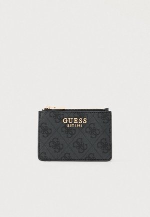 Black cardholder with embossed pattern, gold-tone logo "GUESS EST 1981", zip closure, rectangular shape, textured material, compact design.