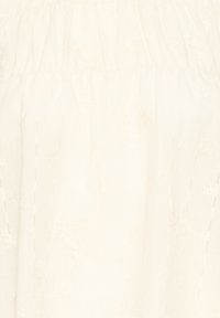 Tissu blanc avec une délicate broderie œillet florale et de subtils détails de couture verticale.