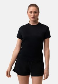 Black athletic t-shirt with short sleeves and round neckline, made from smooth fabric, paired with matching black shorts for a cohesive look.
