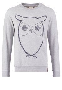 Sweat-shirt gris clair à manches longues avec un simple croquis noir d'une chouette sur le devant, présentant de grands yeux et de petits détails des pattes.