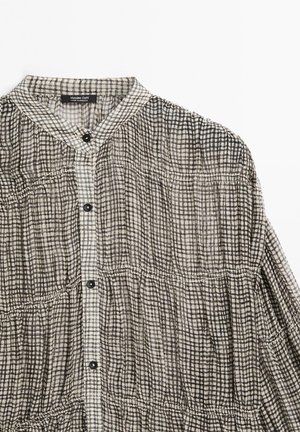 Hnědo-bílá kostkovaná košile s knoflíky, s bandovým límečkem, nařasenými švy a černými knoflíky vpředu.