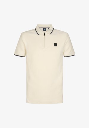 Polo crème avec un motif texturé, manches courtes et col zippé. Présente un logo carré noir sur la poitrine et des accents bleu marine.