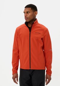 Rote Softshelljacke mit schwarzem Innenfutter, Frontreißverschluss und reflektierenden Akzenten an den Ärmeln. Verfügt über seitliche Reißverschlusstaschen.