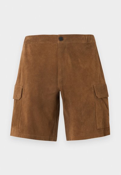 Shorts cargo en daim marron avec fermeture à bouton sur le devant et poches à rabat de chaque côté, sur un fond blanc uni.