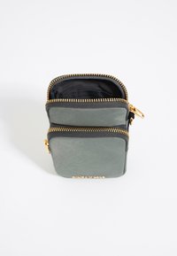 Borsa a zip verde in pelle con hardware dorato, dotata di due scomparti e una superficie texturizzata. Interno foderato in tessuto nero.