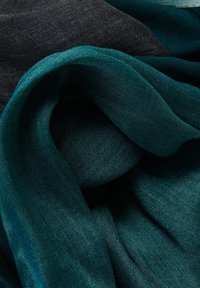 Telas en tonos verde azulado y oscuro colgadas juntas, mostrando una textura suave y ligera con un brillo sutil y una caída suave. Sin patrones distintivos.