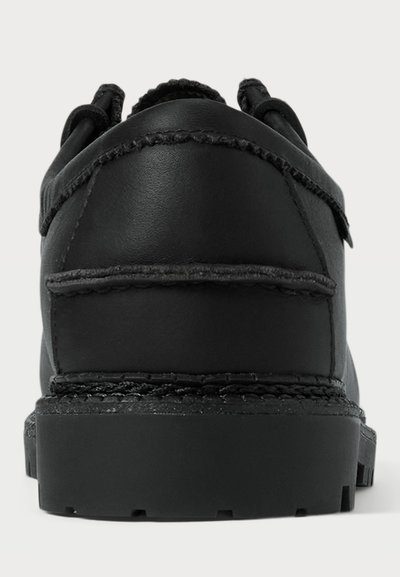 Schwarzer Lederschuh mit abgerundeter Spitze, strukturiertem Finish und kontrastierenden Nähten. Dicke Gummisohle mit gemustertem Profil und gepolstertem Kragen.