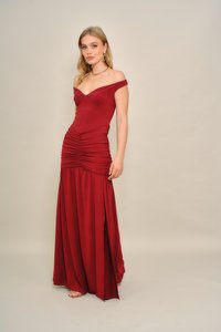 Vállakat szabadon hagyó piros ruha redőzött felsőrésszel és légies szoknyával, oldalán hasítékkal. Simára kidolgozott anyagból készült, testhez simuló szabással.
