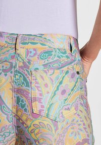 Kleurige gemusterde jeans met een paisleydesign in tinten van roze, teal en geel, gemaakt van denim met een zijzakdetail.