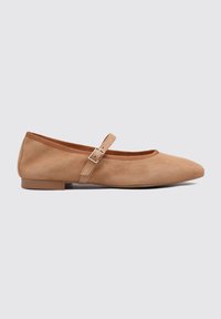Ballerines en daim beige avec un bout rond, dotées d'une fine lanière et d'une boucle en argent sur le cou-de-pied. Semelle basse et plate.