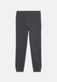 Dark grey leggings made of soft fabric with a fitted design, featuring an elastic waistband and a back pocket. Smooth texture.