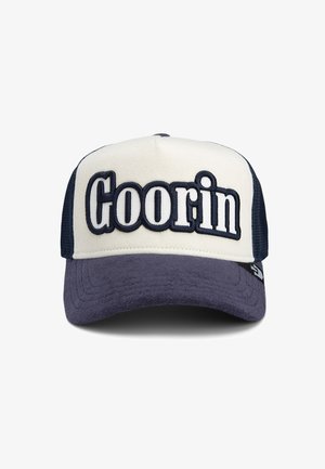 Trucker cap featuring a beige front, navy mesh sides, and a dark blue brim. "Goorin" embroidered prominently on the front in white and navy.