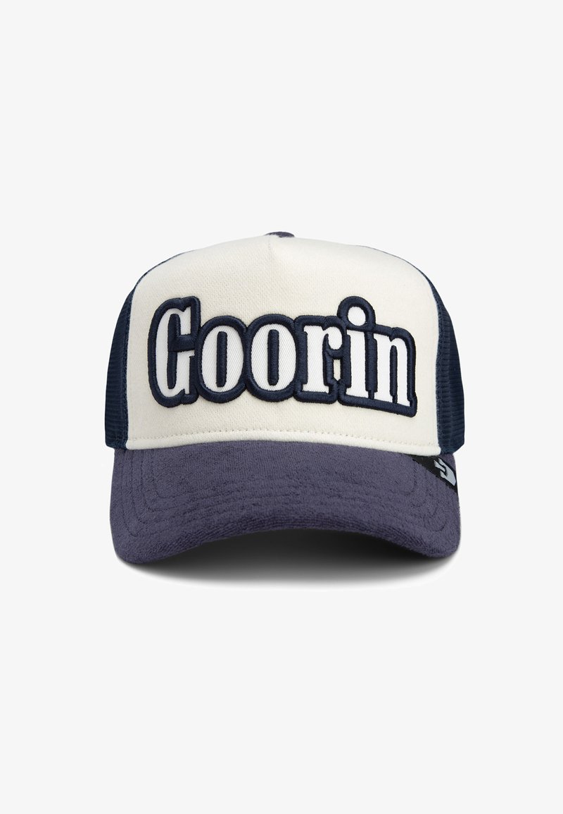 Trucker cap featuring a beige front, navy mesh sides, and a dark blue brim. "Goorin" embroidered prominently on the front in white and navy.