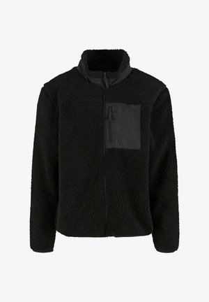 Zwarte fleece jack met een gestructureerde oppervlakte, hoge kraag en een met rits afgesloten borstzak van glad zwart materiaal. Volledige ritsopening aan de voorkant.