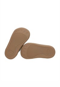 Suole di scarpe in gomma marrone con texture grip e bordi arrotondati. Due suole esposte affiancate, con il logo del brand.