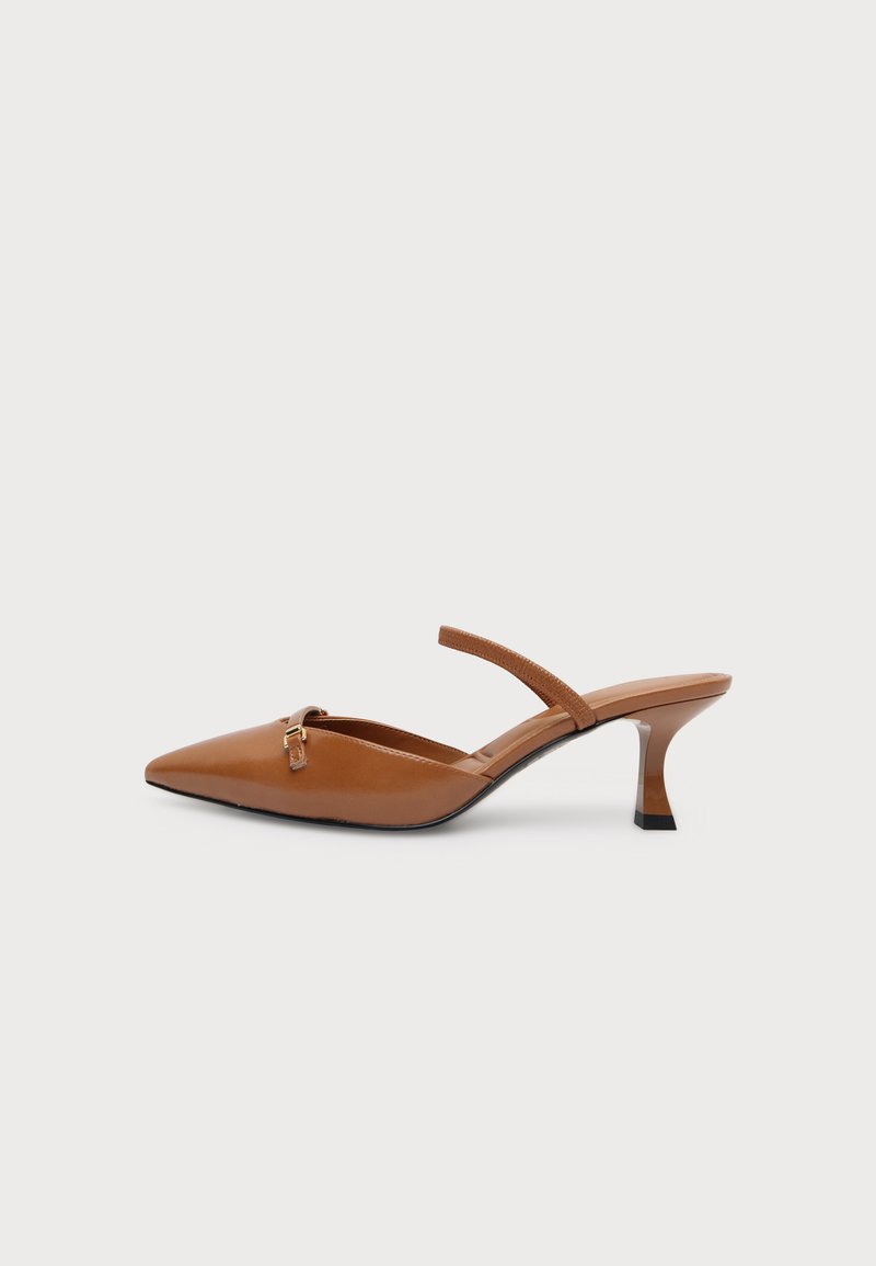 Mule en cuir marron à bout pointu, talon mi-haut fin et une fine bride sur le cou-de-pied avec une petite boucle dorée.