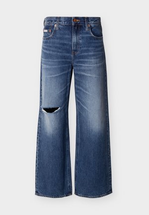 Blauwe wijde spijkerbroeken met een vervaagde wassing en een gescheurd gat op de linker dij, voorzien van voorzakken en een knoopsluiting.