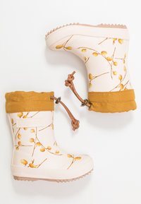 Białe kalosze z żółtymi wzorami kwiatowymi, z żółtym materiałowym mankietem, brązowym sznurkiem i teksturowaną gumową podeszwą.